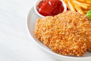 Fried chicken breast fillet steak with French fries and ketchup photo