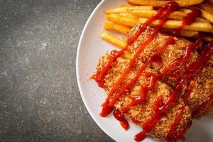 Filete de pechuga de pollo frito con papas fritas y salsa de tomate foto