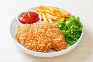 Fried chicken breast fillet steak with French fries and ketchup photo