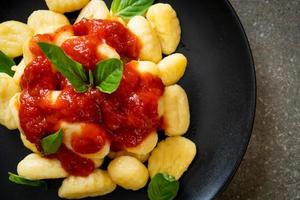Gnocchi in tomato sauce with cheese - Italian food style photo