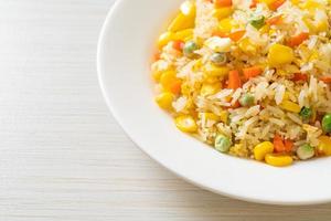 Homemade fried rice with mixed vegetable of carrot, green bean peas, corn, and egg photo