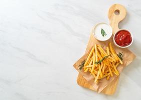 papas fritas con crema agria y salsa de tomate foto