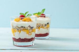 Homemade fresh mango and fresh raspberry with yogurt and granola - healthy food style photo