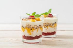 mango fresco casero y frambuesa fresca con yogur y granola - estilo de comida saludable foto