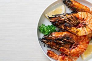 Grilled tiger prawns or shrimps with lemon on a plate photo