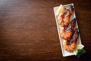 Grilled tiger prawns or shrimps with lemon on a plate photo