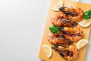 Grilled tiger prawns or shrimps with lemon on a plate photo