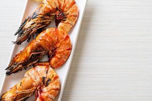 Grilled tiger prawns or shrimps with lemon on a plate photo