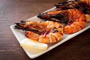 Grilled tiger prawns or shrimps with lemon on a plate photo