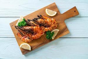 Grilled tiger prawns or shrimps with lemon on a plate photo