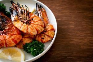 Grilled tiger prawns or shrimps with lemon on a plate photo