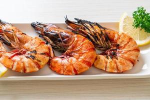 Grilled tiger prawns or shrimps with lemon on a plate photo