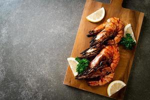 Grilled tiger prawns or shrimps with lemon on a plate photo