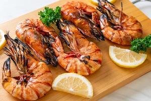 Grilled tiger prawns or shrimps with lemon on a plate photo