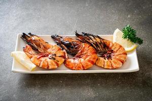 Grilled tiger prawns or shrimps with lemon on a plate photo