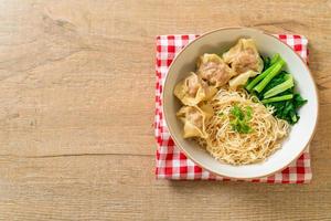Dried egg noodles with pork wonton or pork dumplings without soup Asian food style photo