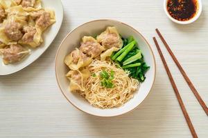 Dried egg noodles with pork wonton or pork dumplings without soup Asian food style photo