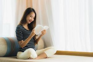 Portrait beautiful young asian woman reading book in on sofa in living room area photo