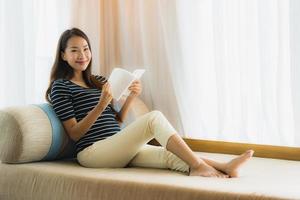 Portrait beautiful young asian woman reading book in on sofa in living room area photo