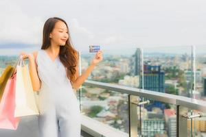 Portrait beautiful young asian woman happy and smile with credit card for shopping bag from department store photo