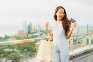 Portrait beautiful young asian woman happy and smile with credit card for shopping bag from department store photo