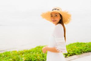 Portrait beautiful asian woman wear hat with smile happy leisure on the beach and sea in holiday vacation photo