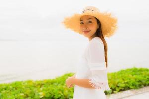 Portrait beautiful asian woman wear hat with smile happy leisure on the beach and sea in holiday vacation photo