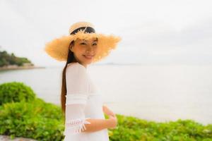 Portrait beautiful asian woman wear hat with smile happy leisure on the beach and sea in holiday vacation photo