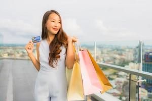 Portrait beautiful young asian woman happy and smile with credit card for shopping bag from department store photo