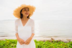 Portrait beautiful asian woman wear hat with smile happy leisure on the beach and sea in holiday vacation photo