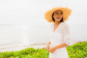 Retrato hermosa mujer asiática usar sombrero con sonrisa feliz ocio en la playa y el mar en vacaciones vacaciones foto