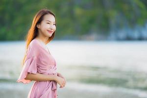 Portrait young beautiful asian woman walk smile and happy on the beach sea and ocean photo