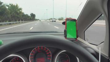 The map gps navigation on modern smartphone green screen device gadget mounted on phone holder in car dashboard doing driving on the expressway go to destination video