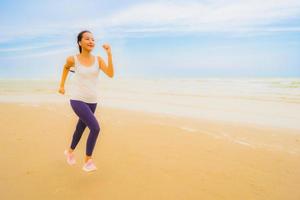 Portrait beautiful young sport asian woman exercise by run and jogging on the outdoor nature beach and sea photo