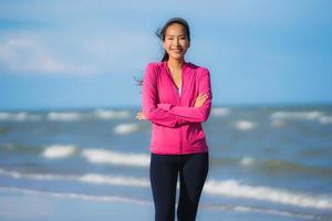 Portrait beautiful young asian woman running and exercising on the tropical outdoor nature beach sea ocean photo