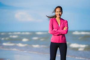 retrato, hermoso, joven, mujer asiática, funcionamiento, y, ejercicio, en, el, tropical, al aire libre, naturaleza, playa, mar, océano foto