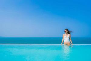 Portrait beautiful young asian woman happy smile relax in swimming pool for travel vacation photo