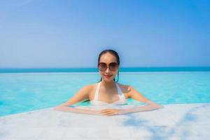 retrato, hermoso, joven, mujer asiática, feliz, sonrisa, relajarse, en, piscina, para, viaje, vacaciones foto