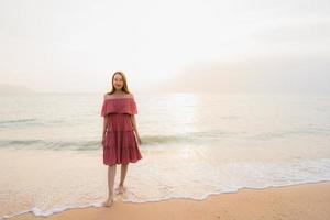 Portrait beautiful young asian woman happy smile leisure on the beach sea and ocean photo