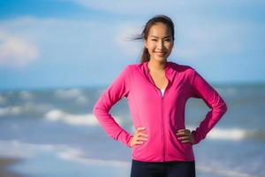 Portrait beautiful young asian woman running and exercising on the tropical outdoor nature beach sea ocean photo