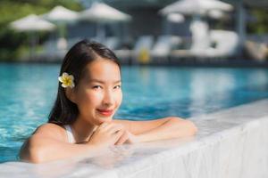 retrato, hermoso, joven, mujer asiática, feliz, sonrisa, en, piscina, alrededor, resort, y, hotel foto