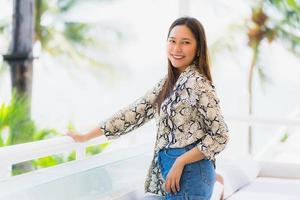 Portrait beautiful young asian woman happy and smile with travel in hotel resort neary sea and beach photo