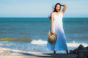 Portrait beautiful young asian woman happy smile relax around neary beach and sea photo