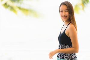 Portrait beautiful young asian woman happy and smile with travel in hotel resort neary sea and beach photo