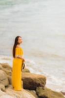 Retrato hermosa mujer asiática usar sombrero con sonrisa feliz ocio en la playa y el mar en vacaciones vacaciones foto