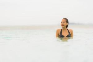 retrato, hermoso, joven, mujer asiática, uso, biquini, alrededor, piscina, en, hotel, resort, casi, mar, océano, playa