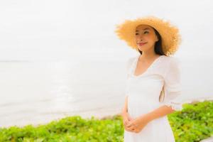 Portrait beautiful asian woman wear hat with smile happy leisure on the beach and sea in holiday vacation photo