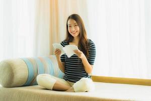 Portrait beautiful young asian woman reading book in on sofa in living room area photo