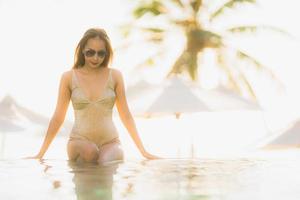 Portrait young beautiful asian woman happy smile and relax in swimming pool around hotel resort photo