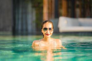 Retrato joven hermosa mujer asiática feliz sonrisa y relajarse en la piscina alrededor del hotel resort foto